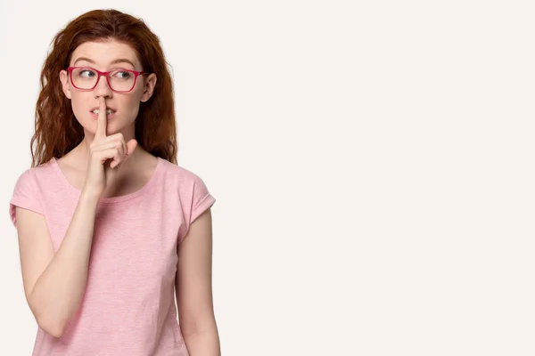 Mladá rusovlasá žena v brýlích dělá tiché gesto, — Stock fotografie