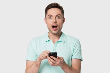 Elinde akıllı telefon tutan şaşırmış genç adamın portresi..