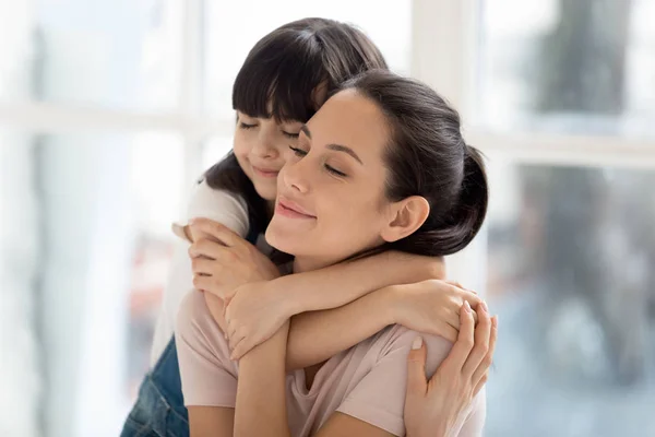 Primer plano de la pequeña hija cariñosa abrazando a la madre joven —  Fotos de Stock
