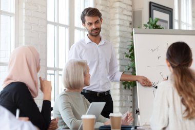 Profesyonel erkek konuşmacıyı dinleyen odaklanmış karışık ırk arkadaşları.