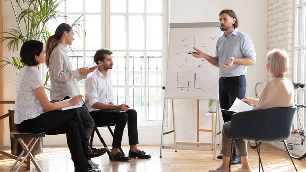 Serios compañeros de equipo maduros y jóvenes que asisten a un taller educativo en la oficina . — Foto de Stock