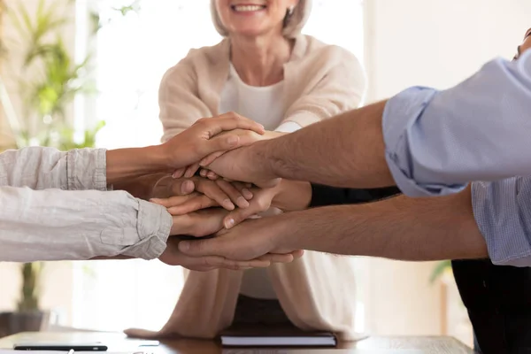Close up happy diverse colleagues putting hands together. — Stock Photo, Image