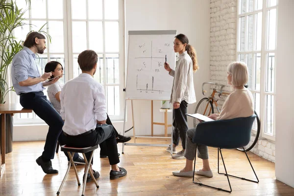 Concentrated multiracial middle aged and young colleagues listening to presenter. — Stock Photo, Image