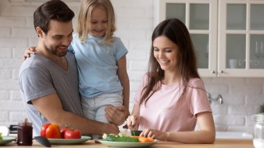 Karım salata için salatalık kesti ve ev halkıyla konuştu.