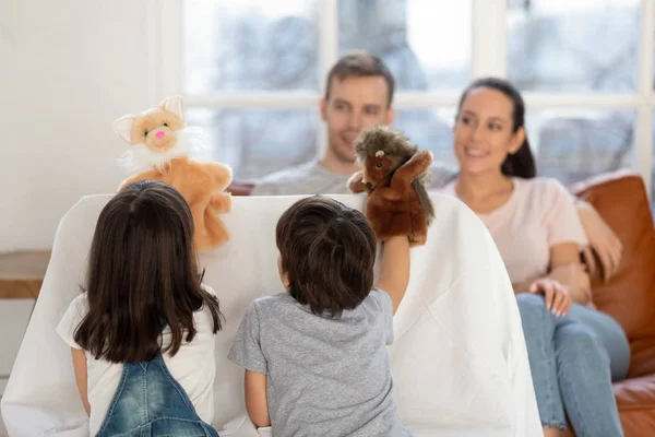 Gelukkig vader en moeder kijken schattig broers en zussen poppenkast. — Stockfoto