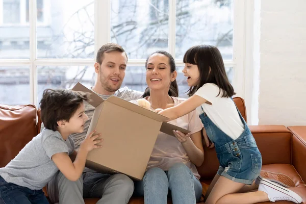 Glad dotter och bror med förälder öppna presentförpackning. — Stockfoto