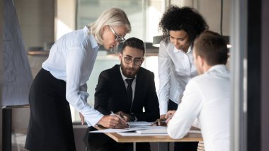 Çeşitli iş adamları takım brifinginde beyin fırtınası yapıyor.