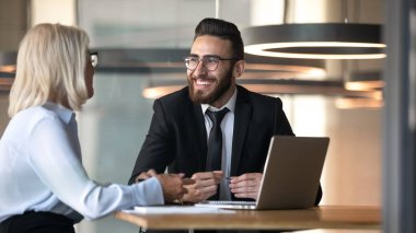 Gülümseyen çeşitli iş adamları ofiste fikir alışverişinde bulundu