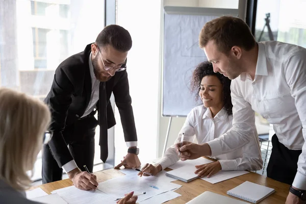 Motivado diversos empleados lluvia de ideas discutir el papeleo en la reunión — Foto de Stock