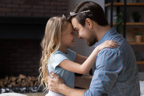 Vater und kleine Tochter tragen Diademe, die sich mit Stirn berühren — Stockfoto
