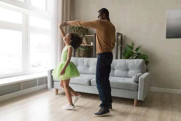 Negro papá danza con feliz hija en verde vestido —  Fotos de Stock