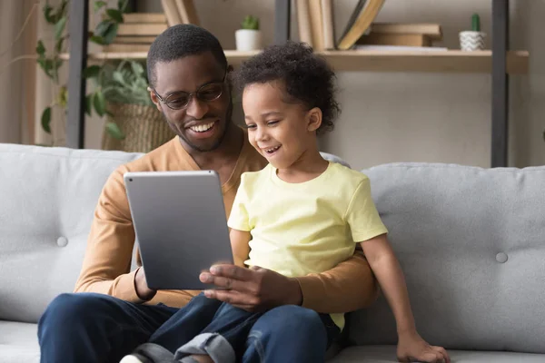 Szczęśliwy czarny tata i mały syn grać w grę na tablecie — Zdjęcie stockowe