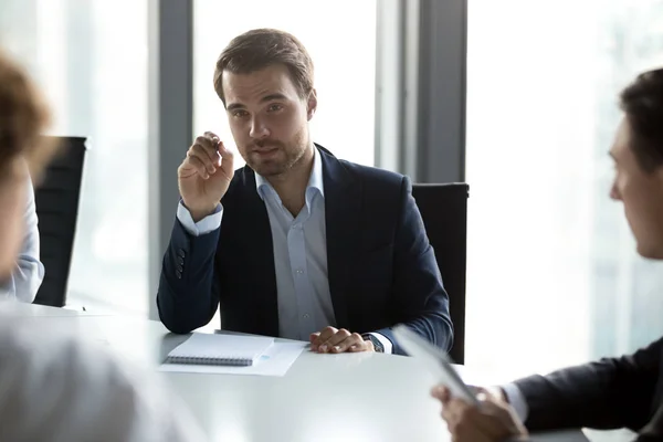 Hombre de negocios serio discutiendo los términos del contrato con los socios comerciales —  Fotos de Stock