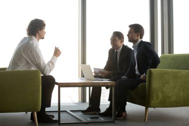 Aday, iş görüşmesinde gülümseyen İK yöneticilerinin sorularını yanıtlıyor