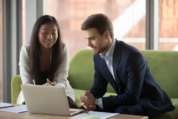 Sonriente mujer de negocios asiática y hombre de negocios utilizando el ordenador portátil juntos —  Fotos de Stock