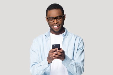 Neşeli gülümseyen Afrikalı Amerikalı genç adam online oyun oynuyor..