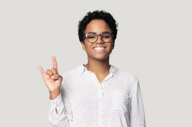 Gülümseyen Afrikalı Amerikalı kadın rock-n-roll işareti gösteriyor..