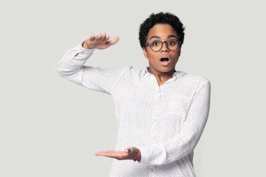 Şaşırmış genç Afrikalı Amerikalı kadın büyük bir gösteri yapıyor..