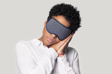 Tired young african american woman sleeping, relaxing with eye mask. clipart