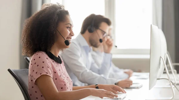 Lächelnder afrikanisch-amerikanischer Mitarbeiter im Headset berät Kunden online — Stockfoto