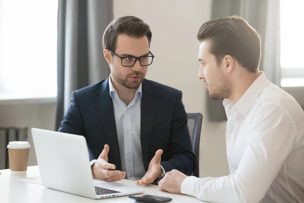 Zakenmensen zitten samen achter een bureau om zakelijke ideeën te bespreken — Stockfoto