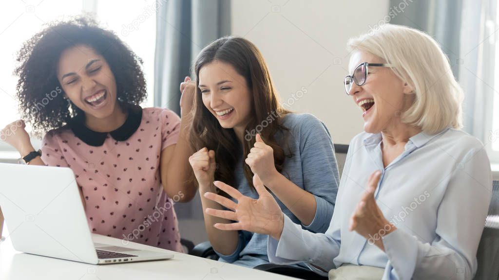 Excited diverse female employees feel euphoric winning online