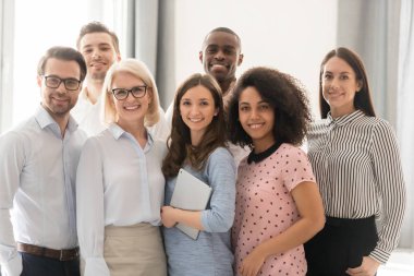 Grup fotoğrafı için gülümseyen çok ırklı çalışanlar