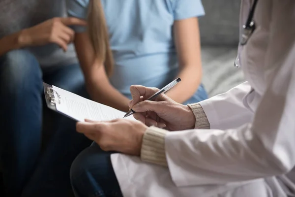 Close up de médico do sexo feminino fazendo anotações no cartão do paciente — Fotografia de Stock