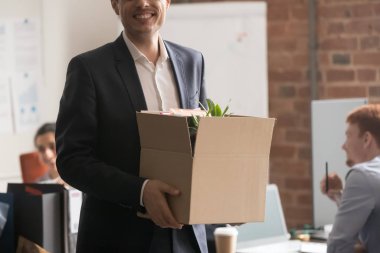 Kırpılmış resim mutlu yeni gelen elinde kişisel eşyalarla duruyor.