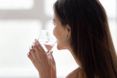 Yatakta genç bir kadın Sabahları saf su içer