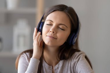 Kulaklıklı genç bayan müzik dinlerken rahatlıyor.