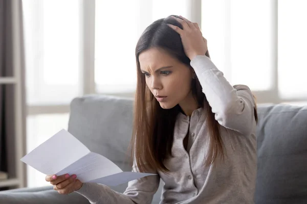 Frustrated girl shocked by bad news in letter — Stock Photo, Image