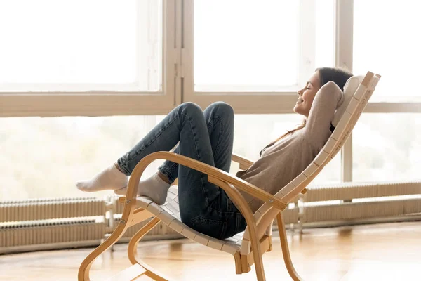 Ragazza sorridente rilassarsi sulla sedia a dondolo godendo del sole — Foto Stock