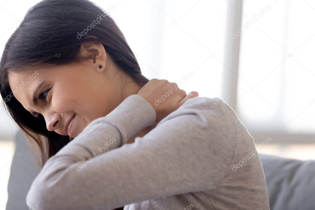Tired young woman massage suffering from neck pain