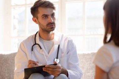 Dost canlısı çocuk doktoru ziyaretinde küçük kız hastayla konuşuyor.