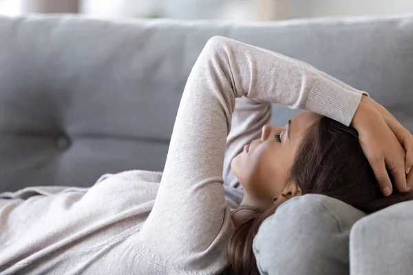 Donna sconvolta sdraiata sul divano soffre di problemi — Foto Stock