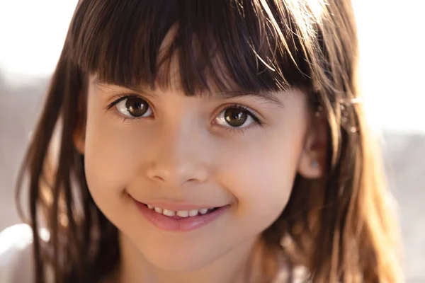 Retrato en la cabeza de una niña sonriente mirando la cámara Imagen de stock