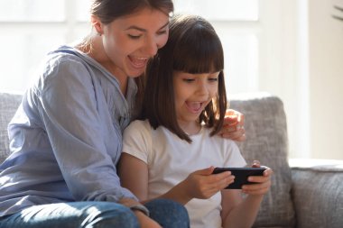 Mutlu anne-kız telefon kullanıyor, oyun oynuyor.