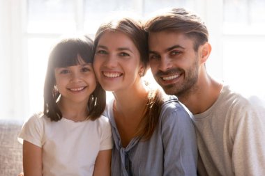 Gülümseyen ailenin, annenin, babanın ve kızının portresi.