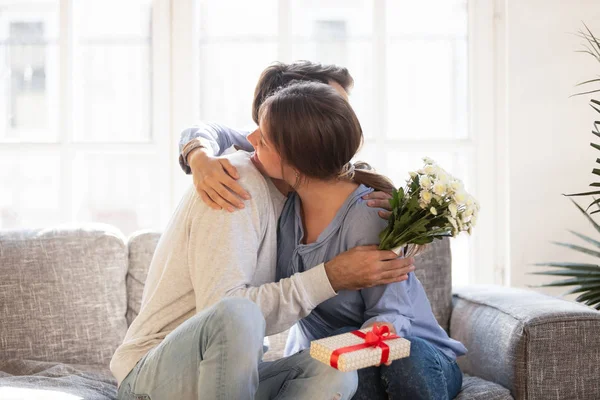 Pareja cariñosa, esposa abrazando marido, agradeciendo por regalo romántico — Foto de Stock