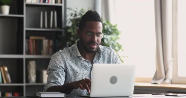 Focused african man typing on laptop work from home office — Stock Video