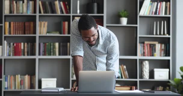 Sorridente uomo d'affari africano stare alla scrivania facendo lavoro online — Video Stock
