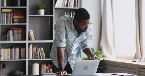 Sério ocupado homem africano trabalhando no laptop pensando resolver problema — Vídeo de Stock