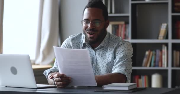 快乐的年轻非洲男生阅读文档时感到兴奋 — 图库视频影像