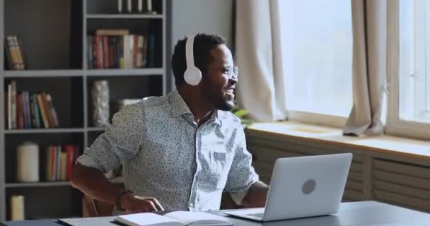 Nadšený africký podnikatel nosit sluchátka baví poslouchat hudbu — Stock video