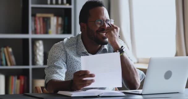 Empolgado afro-americano estudante empregado ler boas notícias em carta — Vídeo de Stock