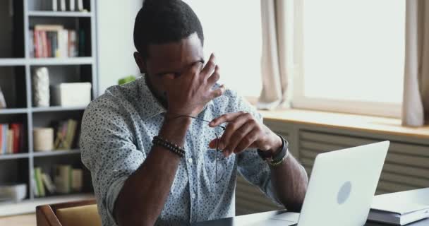 Un homme d'affaires africain fatigué enlève ses lunettes en massant les yeux secs et irrités — Video