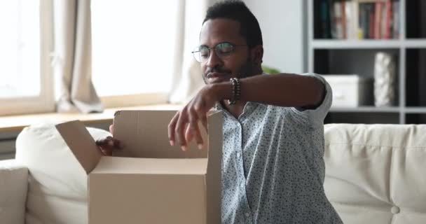 Happy african man customer open cardboard box receive parcel — Stock Video