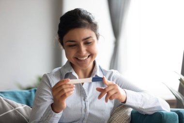 Hamile, mutlu Hintli kadın hamilelik testi pozitif sonuç veriyor.