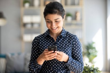 Akıllı telefon kullanan mutlu Hintli genç kadın.